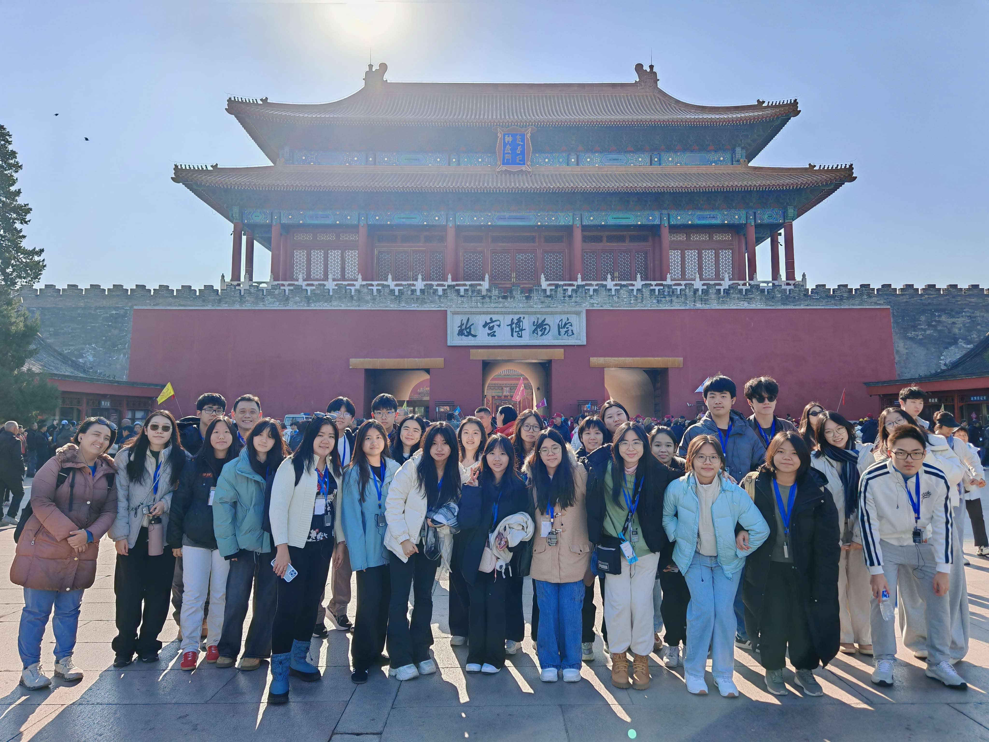 A group of students and teachers posing in front of the Palace Museum in Beijing.